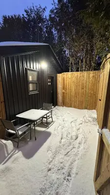 a snow covered patio with a picnic table and a fence at Cozy Studio Retreat in Scenic Georgina, Canada in Georgina