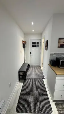 a hallway with a door and a bench in a room at Cozy Studio Retreat in Scenic Georgina, Canada in Georgina