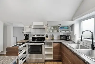 a kitchen with stainless steel appliances and a sink at Modern 1 Bdrm with Laundry, BBQ, Deck in Welland