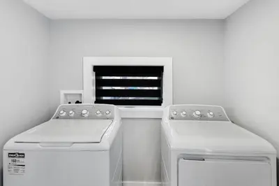 a kitchen with two machines and a window at Modern 1 Bdrm with Laundry, BBQ, Deck in Welland