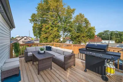 a patio with a grill and furniture on a deck at Modern 1 Bdrm with Laundry, BBQ, Deck in Welland