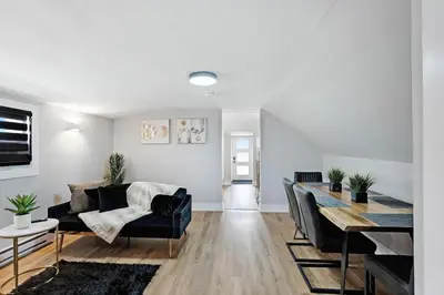 a living room with a couch and a dining table at Modern 1 Bdrm with Laundry, BBQ, Deck in Welland