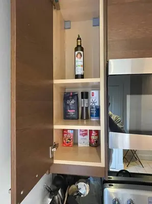 a kitchen cupboard with spices and a bottle of alcohol at 2 Bed Apartment in DT Toronto with Free Parking in Toronto