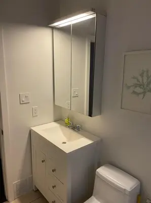 a bathroom with a sink and a toilet and a mirror at 2 Bed Apartment in DT Toronto with Free Parking in Toronto