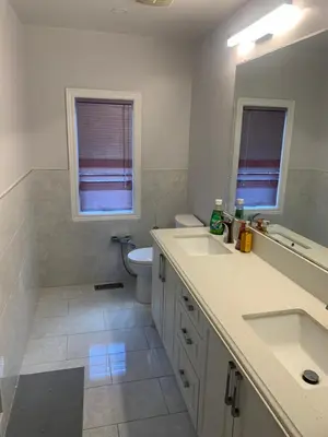 a white bathroom with two sinks and a toilet at Cozy House in Richmond Hill