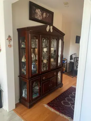 a wooden cabinet with glass doors in a living room at Cozy House in Richmond Hill