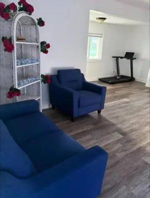 a living room with a blue couch and a table at Cozy Fort Erie crystal Beach house in Fort Erie