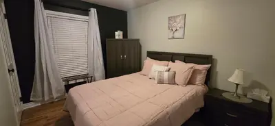a bedroom with a bed with pink pillows and a window at Paradise Haven in Arthur