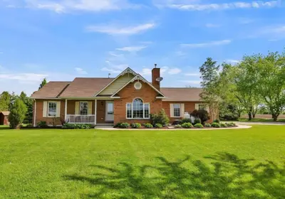 a brick house with a green lawn at Paradise Haven in Arthur