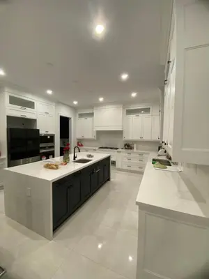 a large kitchen with white cabinets and a sink at Modern Living near Yonge St in Toronto