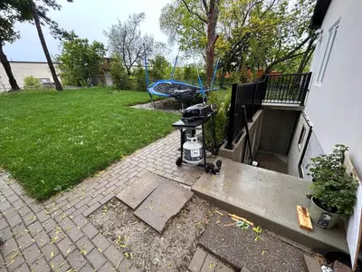 a backyard with a barbecue grill and a yard at The Pantry Suite - Cozy Basement Stay in Mississauga