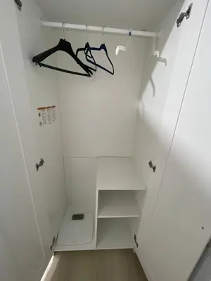 a walk in closet with white walls and white shelves at The Pantry Suite - Cozy Basement Stay in Mississauga