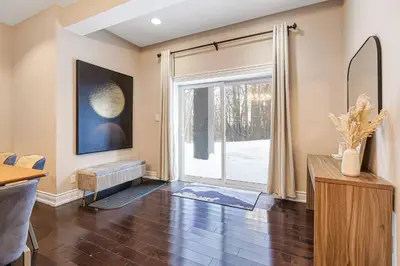 a living room with a large window and a table at Modern 3BR Home in Stouffville | Quiet & Spacious in Aurora