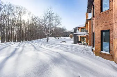a snow covered street next to a brick building at Modern 3BR Home in Stouffville | Quiet & Spacious in Aurora
