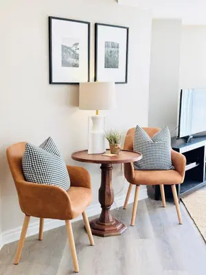 a living room with two chairs and a table with a lamp at Designer Escape by the Pond in Kitchener