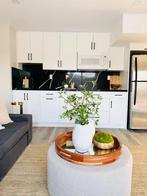 a kitchen with white cabinets and a coffee table in a living room at Designer Escape by the Pond in Kitchener