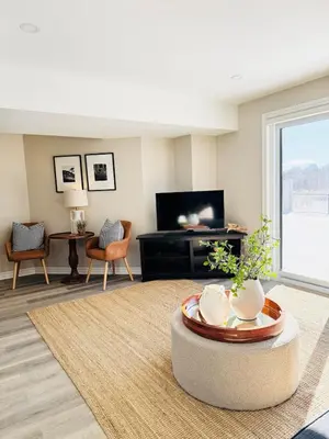 a living room with a table and a tv at Designer Escape by the Pond in Kitchener