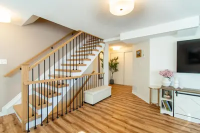 a living room with a staircase and a tv at Cozy Barrie retreat near lake Simcoe and parks in Barrie