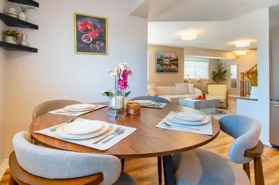a dining room and living room with a wooden table and chairs at Cozy Barrie retreat near lake Simcoe and parks in Barrie