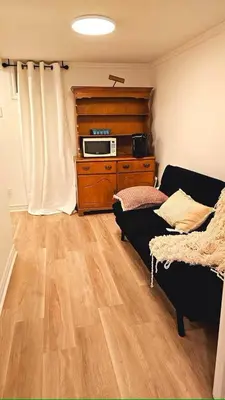 a living room with a couch and a microwave on a dresser at Multi-level home near Squareone, Airport, 3Parking in Mississauga