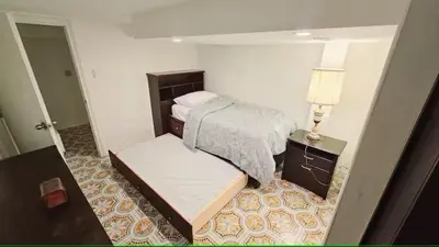 a bedroom with a bed and a table and a lamp at Multi-level home near Squareone, Airport, 3Parking in Mississauga