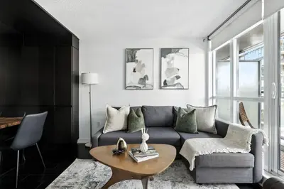 a living room with a couch and a table at Modern CityPlace Retreat King Bed & Balcony in Toronto