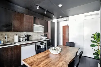 a kitchen with a wooden table and chairs at Modern CityPlace Retreat King Bed & Balcony in Toronto