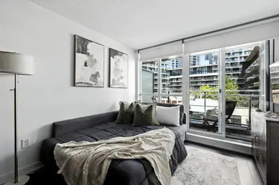 a bedroom with a bed and a large window at Modern CityPlace Retreat King Bed & Balcony in Toronto