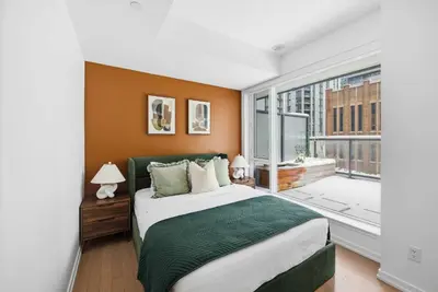 a bedroom with a large bed and a large window at Stunning 2BR Downtown Condo w Huge Private Patio in Toronto