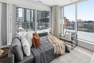 a living room with a couch and large windows at Stunning 2BR Downtown Condo w Huge Private Patio in Toronto