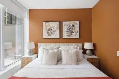 a bedroom with a white bed with two lamps and a window at Stunning 2BR Downtown Condo w Huge Private Patio in Toronto
