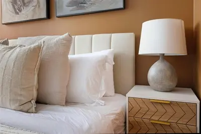 a bed with white pillows and a lamp on a table at Stunning 2BR Downtown Condo w Huge Private Patio in Toronto