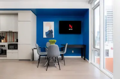 a dining room with blue walls and a table and chairs at Designer 1BR Condo Entertainment District in Toronto