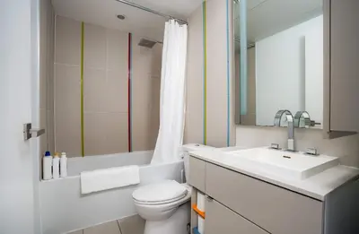 a bathroom with a white toilet and a sink at Designer 1BR Condo Entertainment District in Toronto