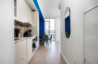 a kitchen with white cabinets and a blue wall at Designer 1BR Condo Entertainment District in Toronto