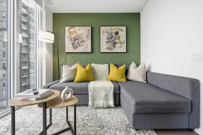 a living room with a gray couch and yellow pillows at Heart of the City 1BR Condo Walk Everywhere in Toronto