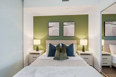 a bedroom with a large bed with blue pillows at Heart of the City 1BR Condo Walk Everywhere in Toronto