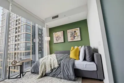 a bedroom with a bed and a green wall at Heart of the City 1BR Condo Walk Everywhere in Toronto