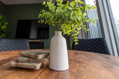 a white vase sitting on a wooden table with a plant at Heart of the City 1BR Condo Walk Everywhere in Toronto
