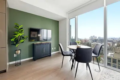 a dining room with a table and chairs and a large window at Heart of the City 1BR Condo Walk Everywhere in Toronto