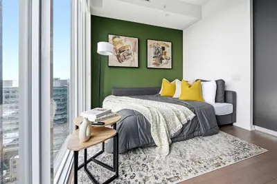 a bedroom with green walls and a bed with yellow pillows at Heart of the City 1BR Condo Walk Everywhere in Toronto