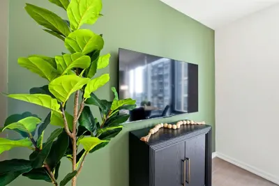 a living room with a tv and a plant at Heart of the City 1BR Condo Walk Everywhere in Toronto
