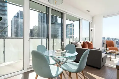 a living room with a glass table and chairs at Modern 2BR in the Entertainment Hub with Parking in Toronto