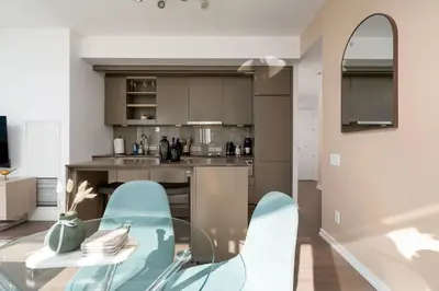 a kitchen with a glass table and blue chairs at Modern 2BR in the Entertainment Hub with Parking in Toronto