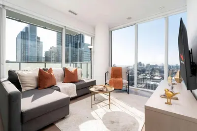 a living room with a couch and large windows at Modern 2BR in the Entertainment Hub with Parking in Toronto