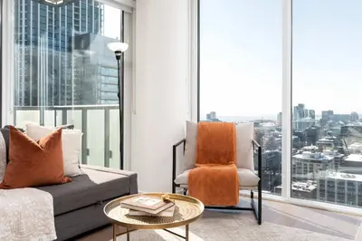 a living room with a couch and a chair and a large window at Modern 2BR in the Entertainment Hub with Parking in Toronto