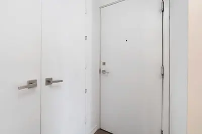 three white lockers in a white room at Modern 2BR in the Entertainment Hub with Parking in Toronto