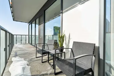a balcony with chairs and a table on a building at Modern 2BR in the Entertainment Hub with Parking in Toronto