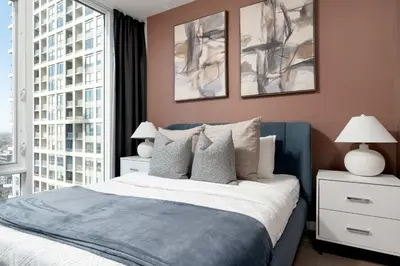 a bedroom with a blue bed and two windows at Modern 2BR in the Entertainment Hub with Parking in Toronto