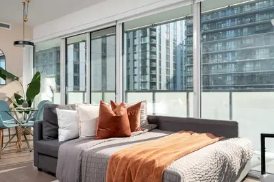 a bedroom with a bed and a large window at Modern 2BR in the Entertainment Hub with Parking in Toronto